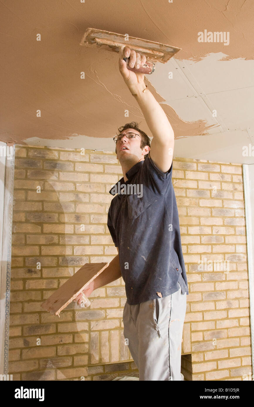 a plasterer skimming a ceiling in a new home Stock Photo Alamy