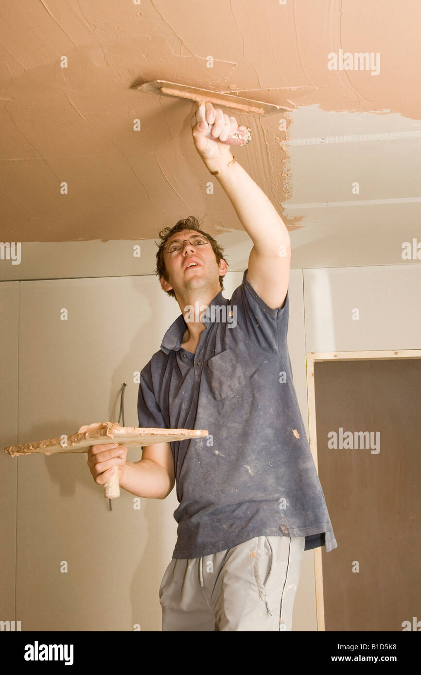 a plasterer skimming a ceiling in a new home Stock Photo Alamy