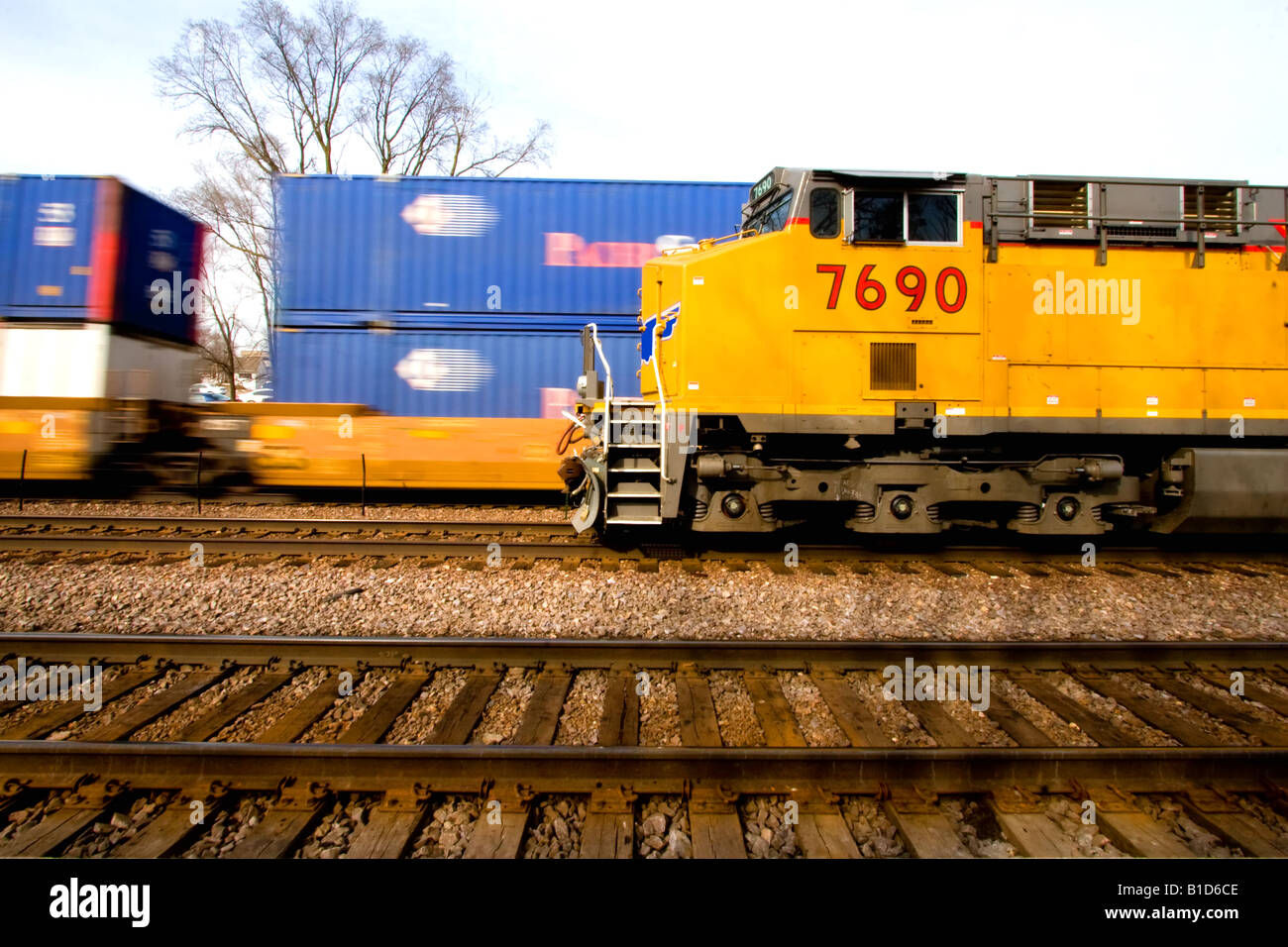 Two trains pass, one moving at a high rate of speed. Stock Photo