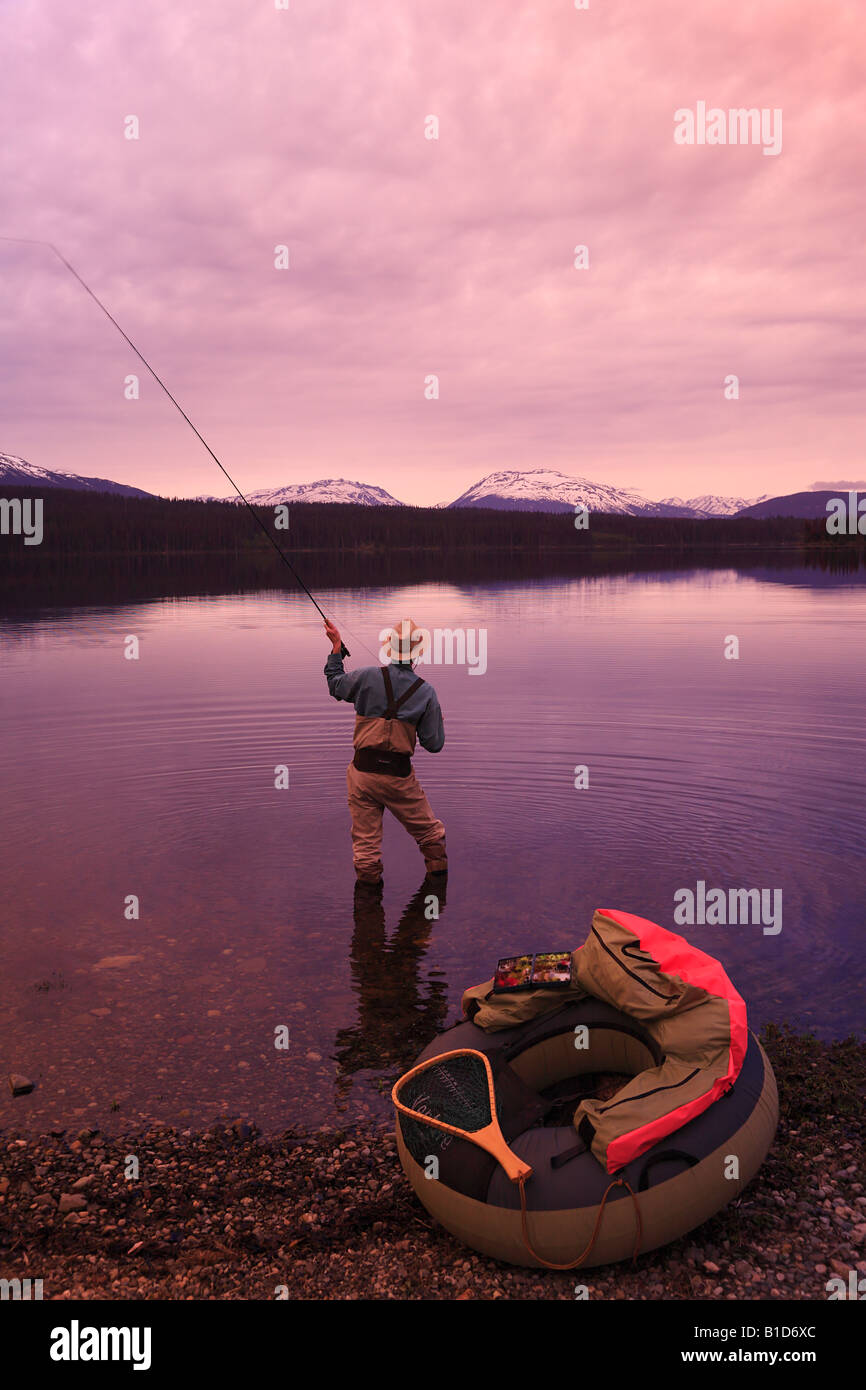 Flyfisherman casting for trout at dawn McBride Lake near Morice Lake BC Stock Photo