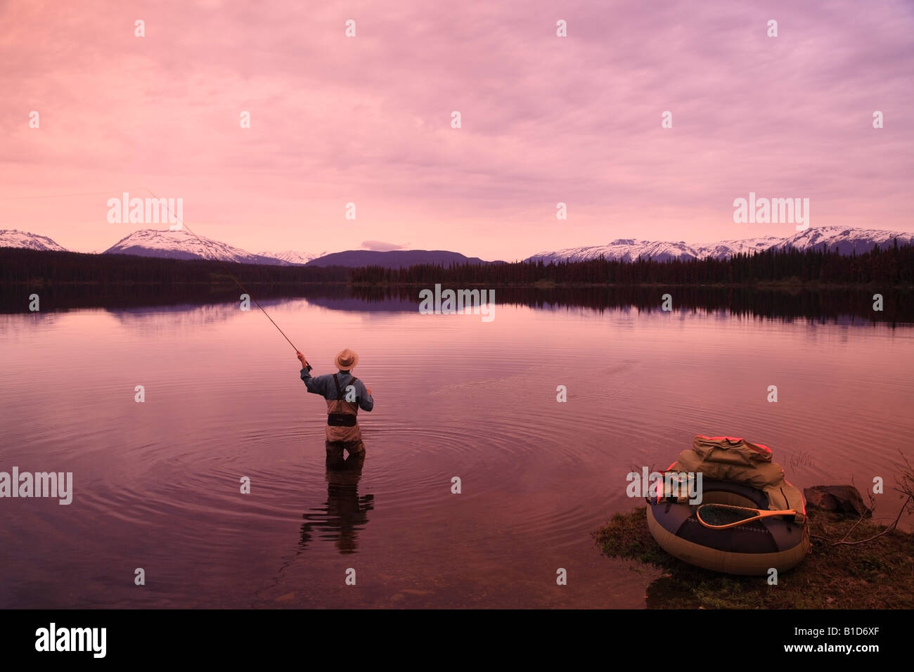 Flyfisherman casting for trout at dawn McBride Lake near Morice Lake BC Stock Photo