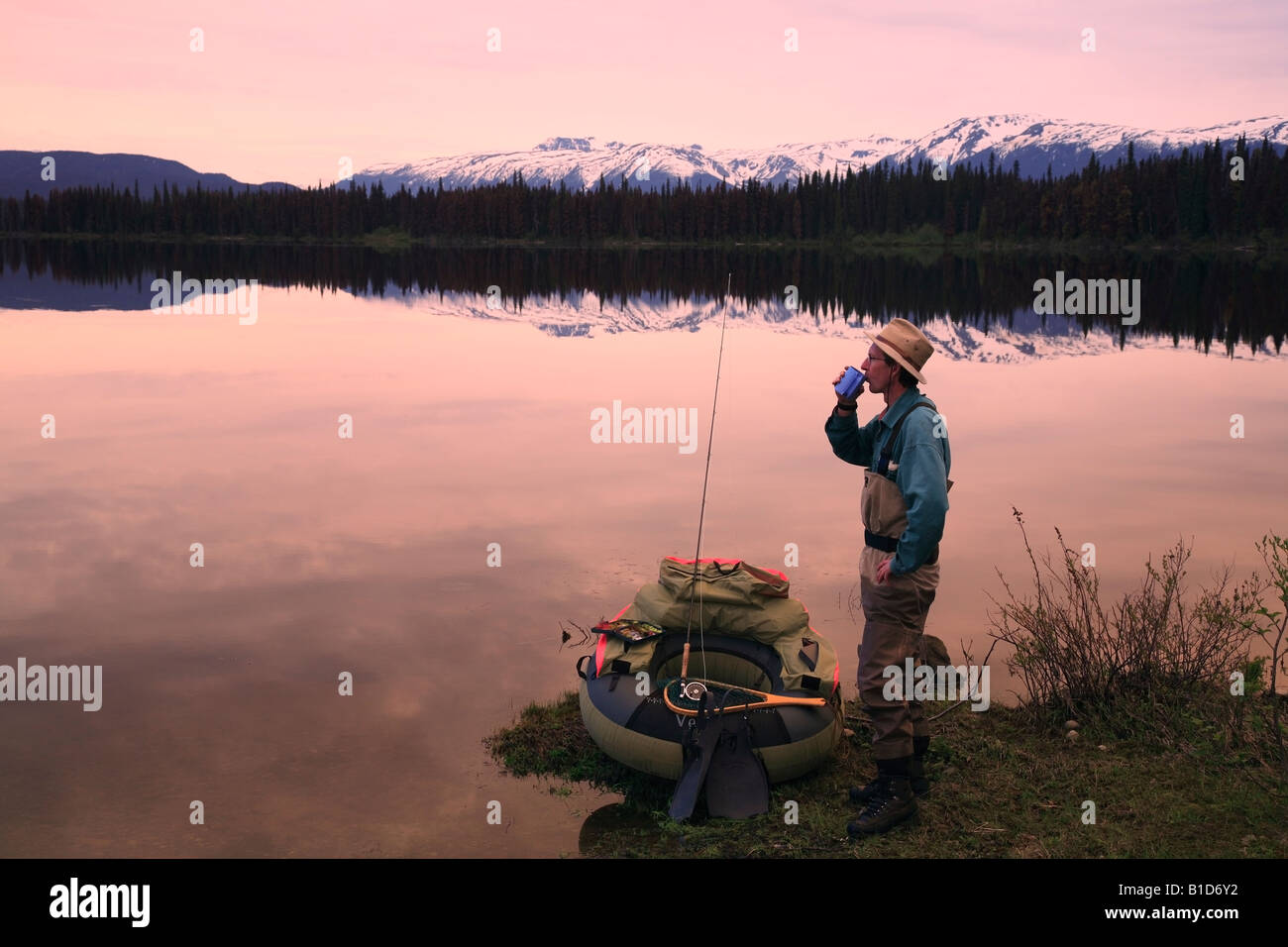 Flyfisherman having morning coffee on shoreline of McBride Lake near Morice Lake BC Stock Photo
