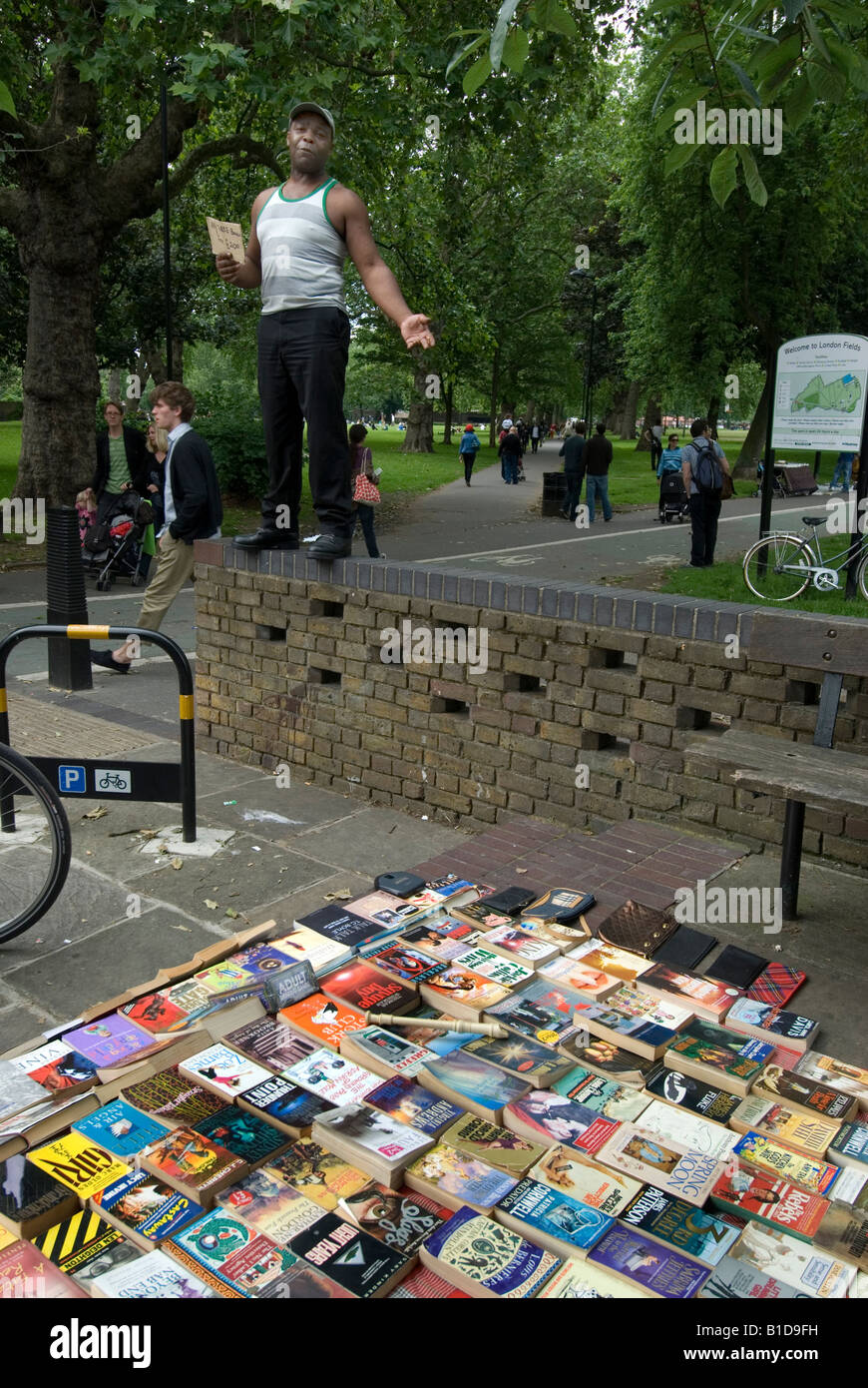 London Fields Book seller standing on wall to advertise his books and