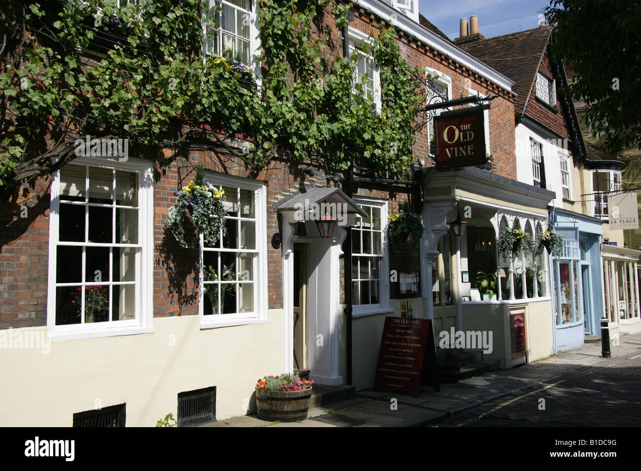 City of Winchester, England. The Old Vine 18th century inn with other shop fronts at Winchester’s Great Minister Street. Stock Photo