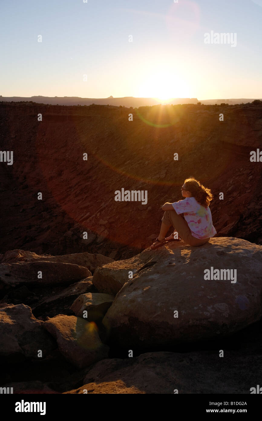 Lone female camper enjoys the sunset, Murphy Camp, White Rim Trail, Canyonlands National Park, Utah Stock Photo