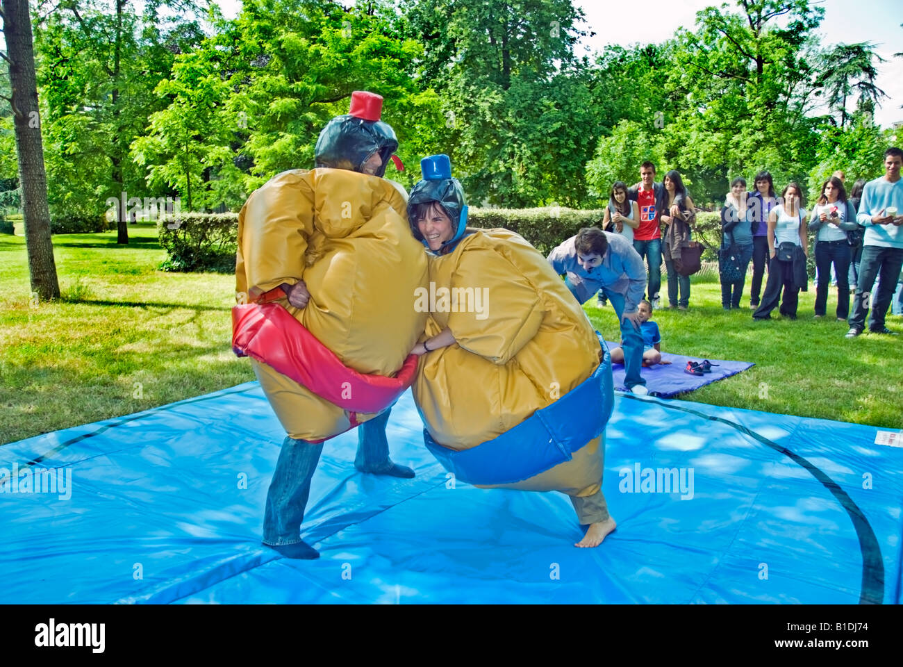 Paris France, Group Young People Watching Two Teens 'Sumo Wrestlers' in Costume Fighting Outside in 'Parc de Vincennes' Stock Photo