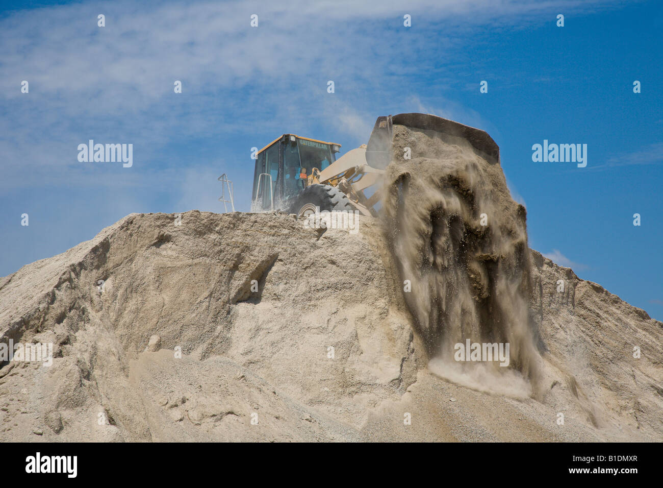 Front End Loader dumps dirt over top of pile Stock Photo