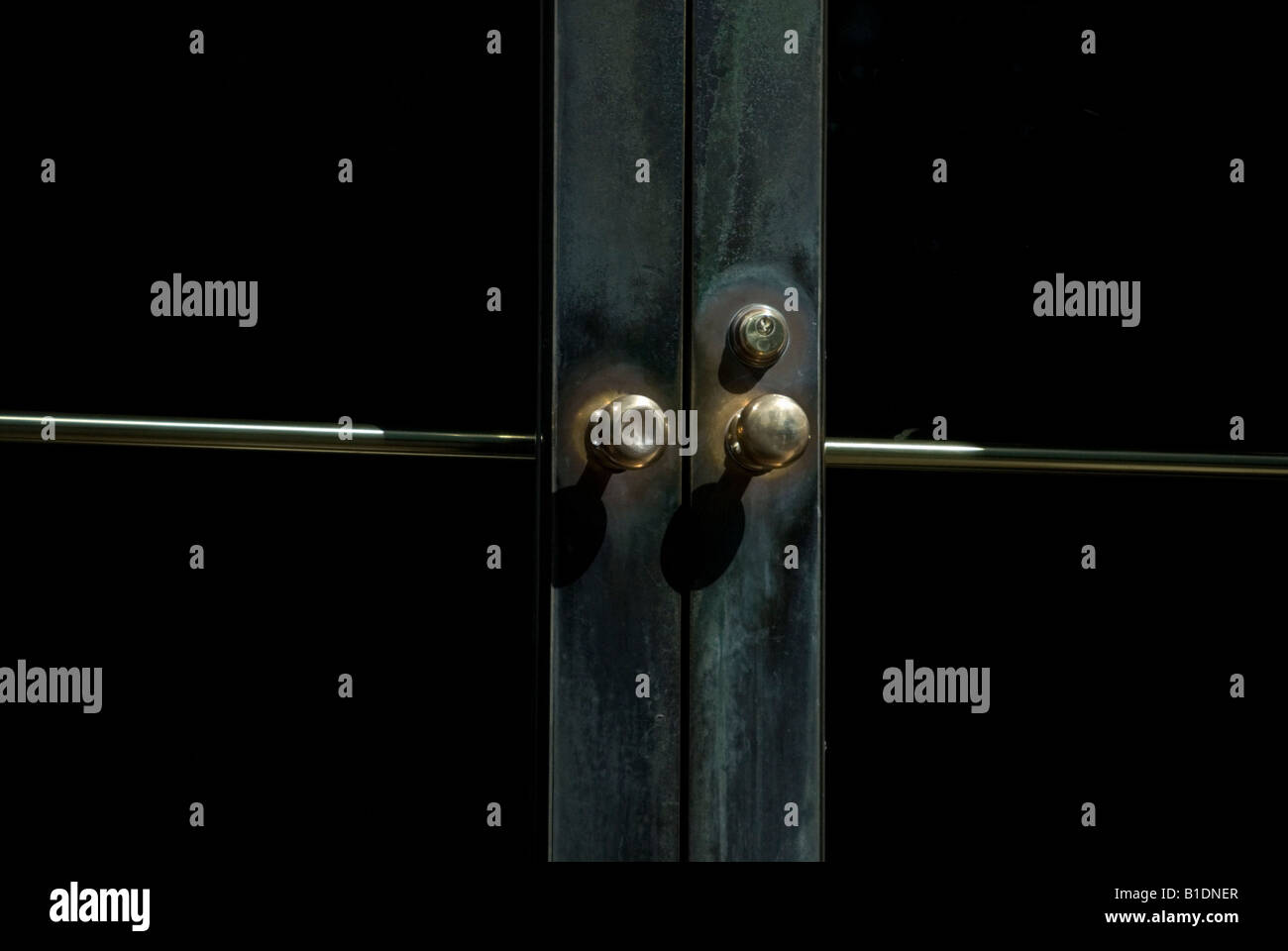 Close-up of an a beautifully worn door with brass knobs and lock. Stock Photo