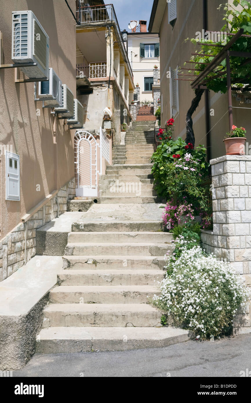 Moscenicka Draga Istria Croatia Stone steps in narrow alleyway between old buildings with air conditioning units on wall Stock Photo
