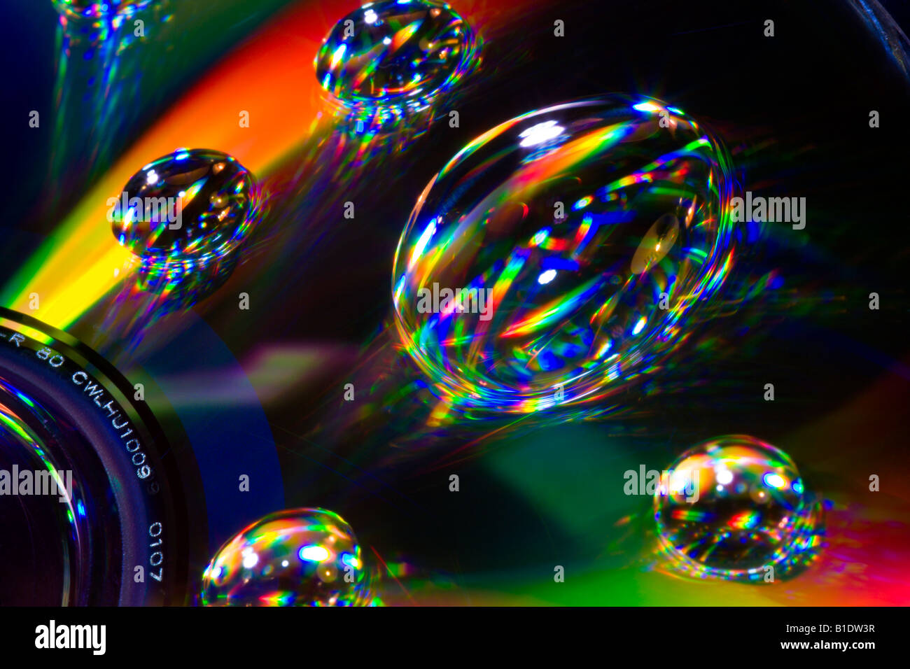 Light spectrum reflecting in water bubbles on CD DVD disk Stock Photo