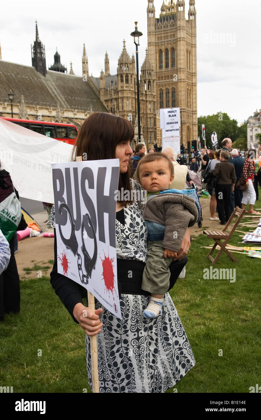 Woman Demonstrator with child outside the Houses of Parliament in Parliament Square in London as President Bush arrives Stock Photo