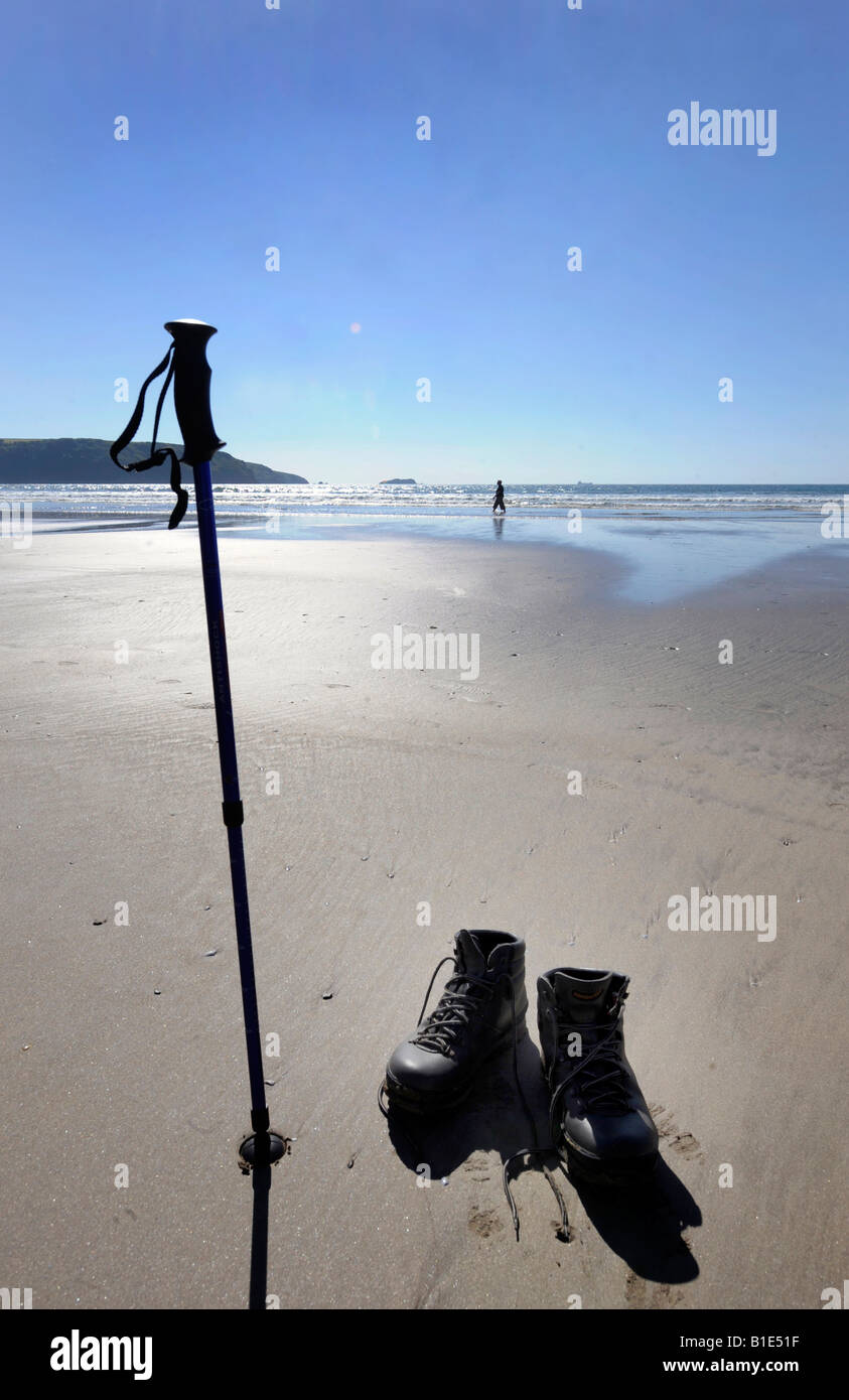 A LONE WALKER TAKES A BREAK FROM HER WALK AND PADDLES IN THE SEA ON THE WELSH COAST,UK. Stock Photo