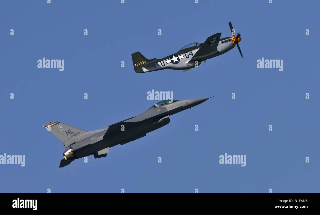 A F-16 jet fighter and a P-51 Mustang fighter flying together Stock Photo