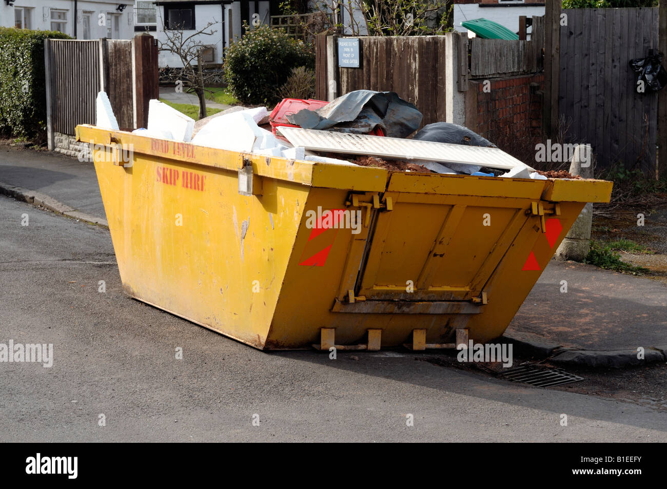 Yellow skip on the side of the road Stock Photo Alamy