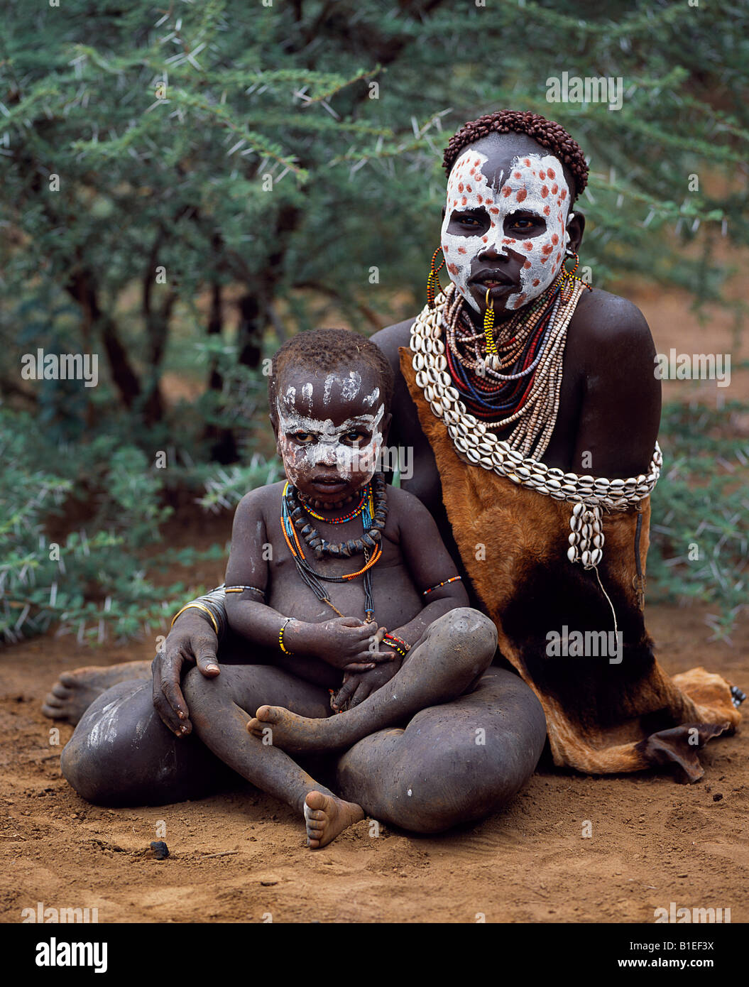 A Karo woman sits with child.  A small Omotic tribe related to the Hamar, who live along the banks of the Omo River. Stock Photo