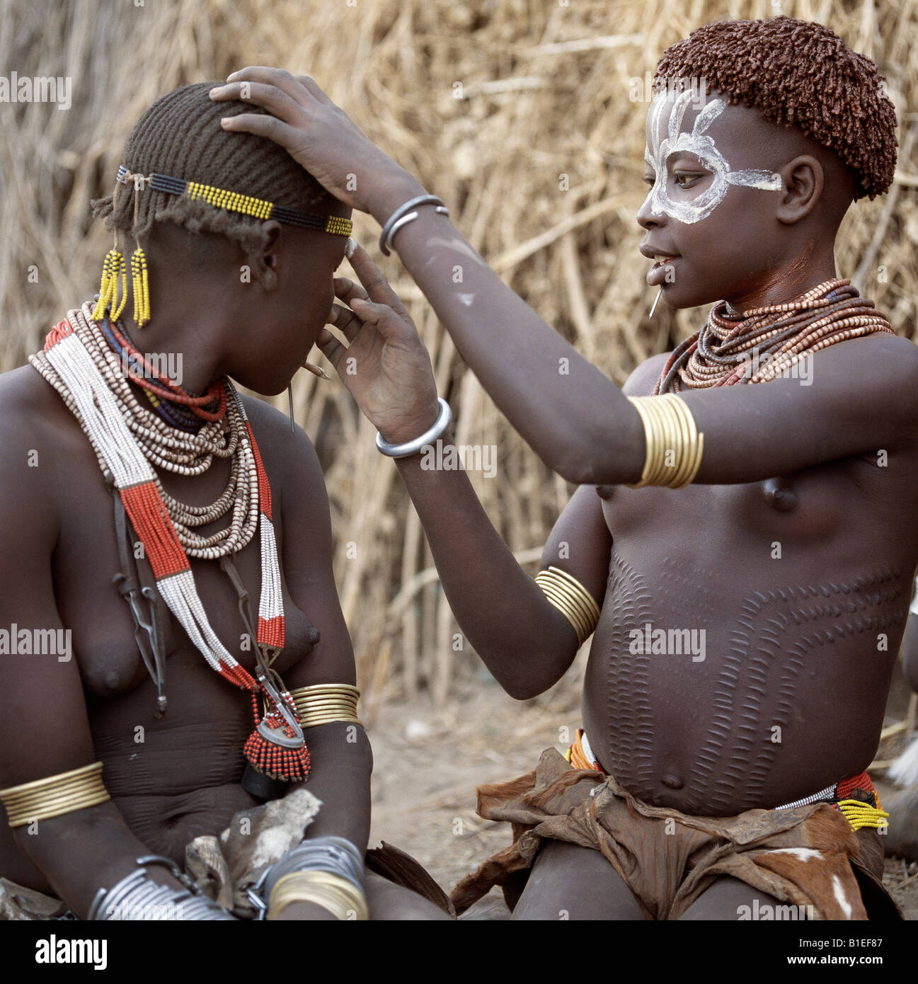 Karo girls paint their faces in preparation for a dance.  It is a tradition for girls to pierce a hole below the lower lip. Stock Photo