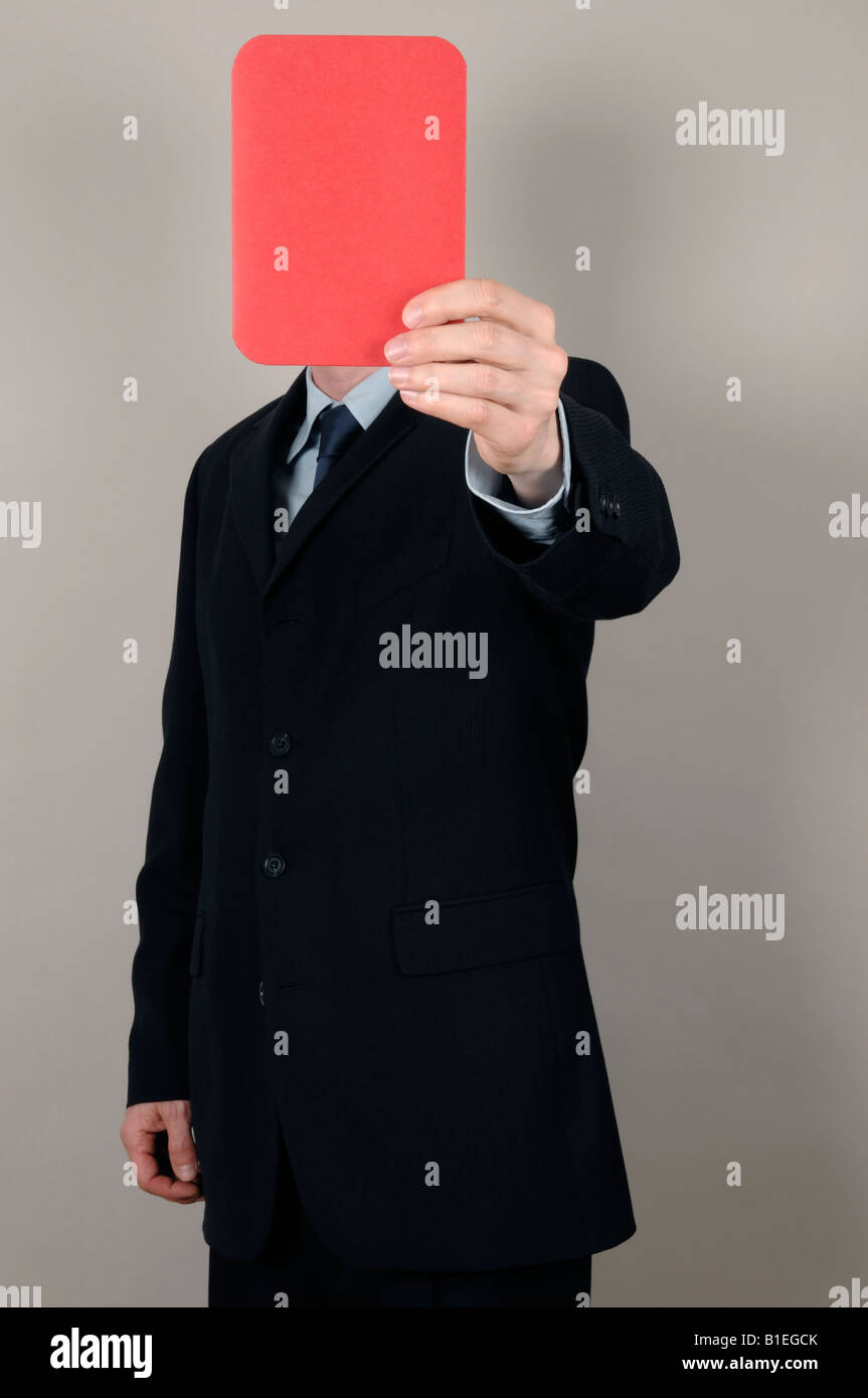 Businessman holding a red card in front of face Stock Photo