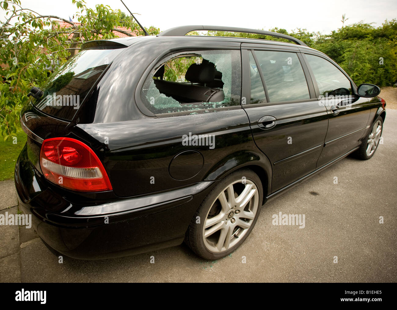 Smashed rear quarter window of black Jaguar car parked on a York street ...