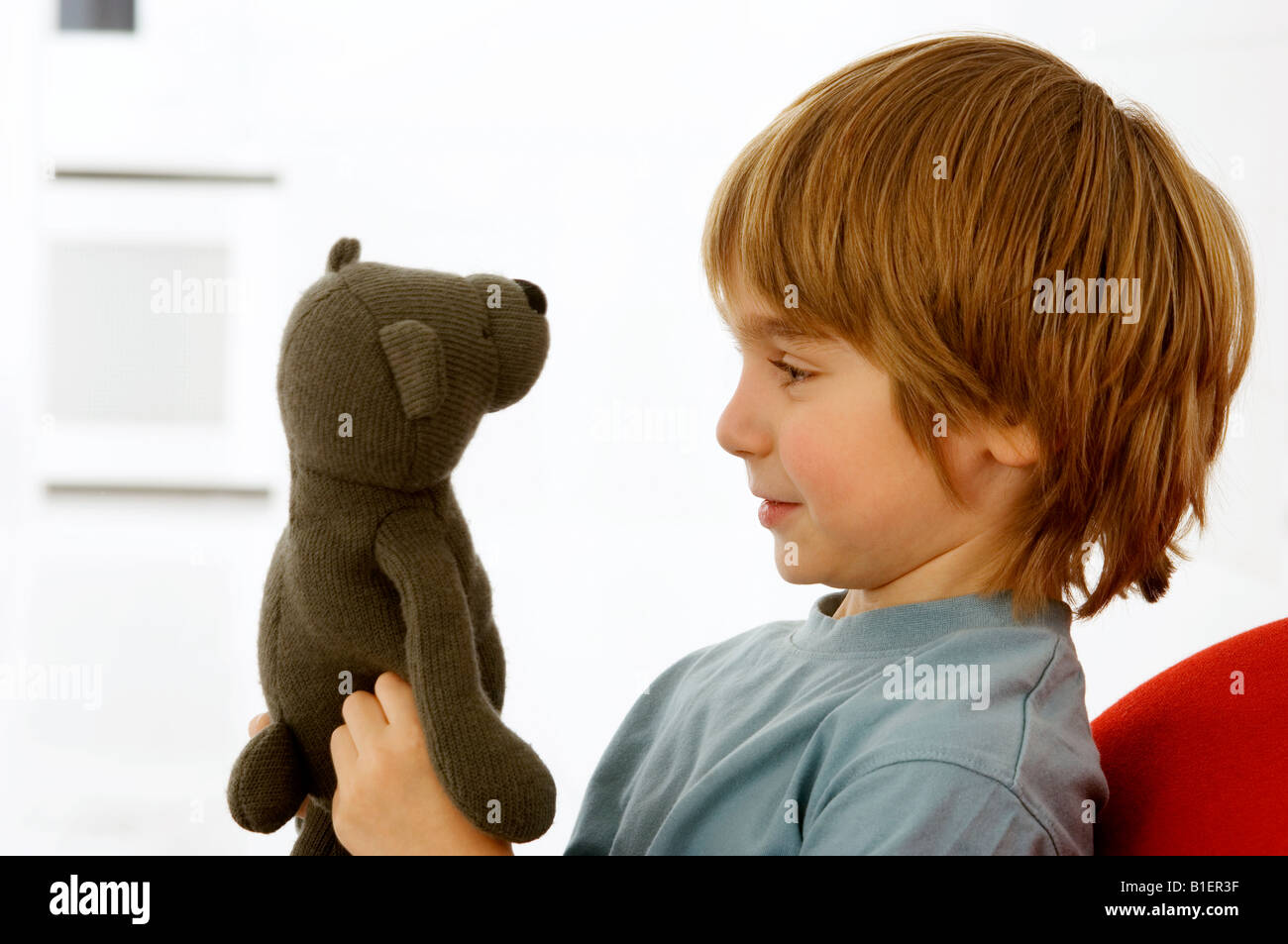 Side profile of a boy holding a teddy bear Stock Photo - Alamy