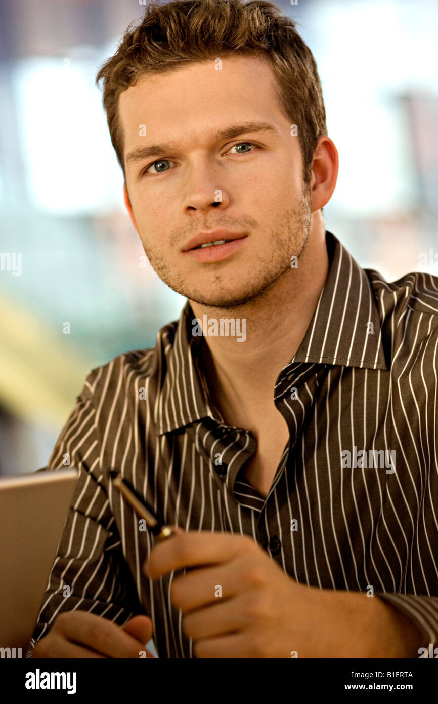 Portrait of a businessman holding a pen Stock Photo - Alamy