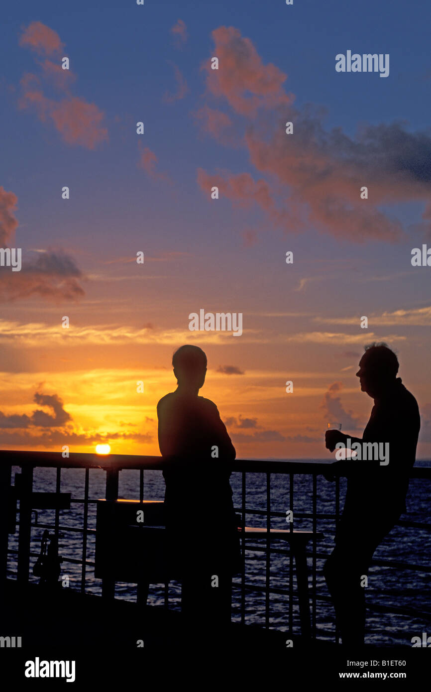 A couple onboard a world cruise watches the sun dip into the Atlantic. Stock Photo