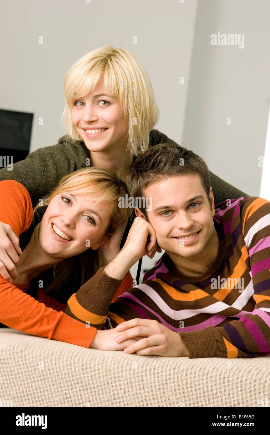 Portrait of a young man smiling with two young women Stock Photo - Alamy
