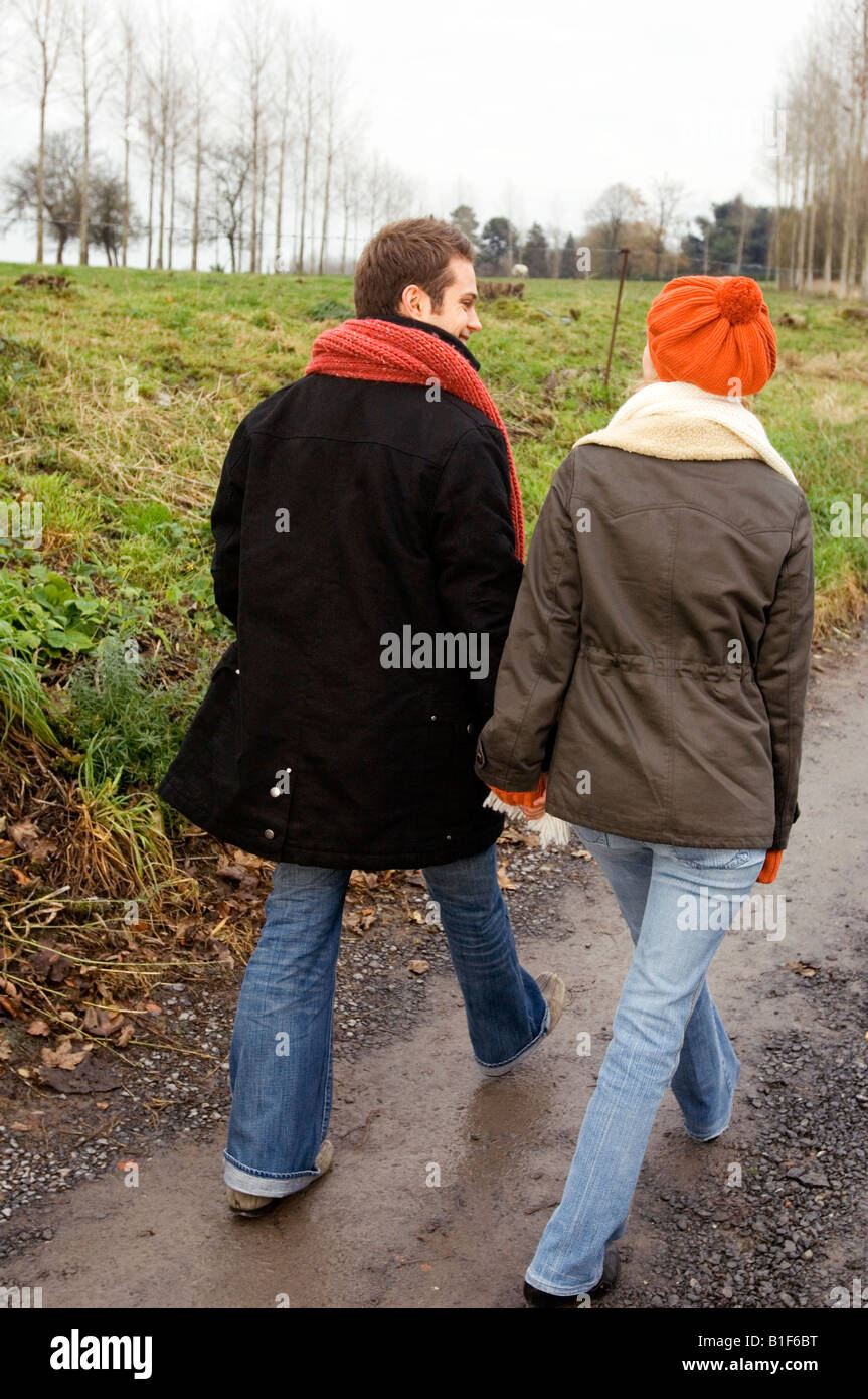Rear view of a young couple walking on a dirt road Stock Photo - Alamy