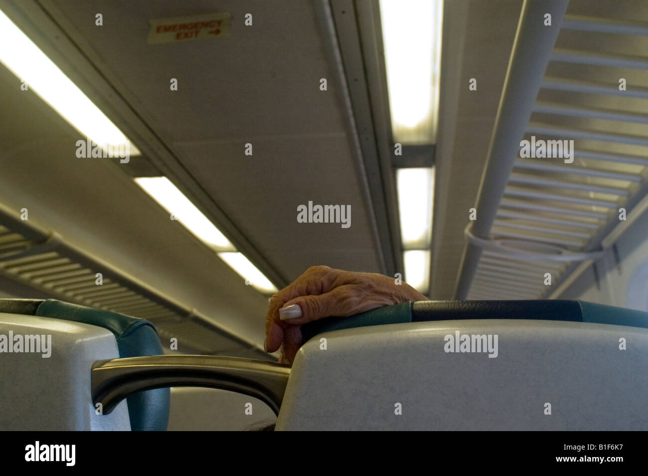 Elderly woman s hand rests on seat back on the Long Island Railroad Stock Photo