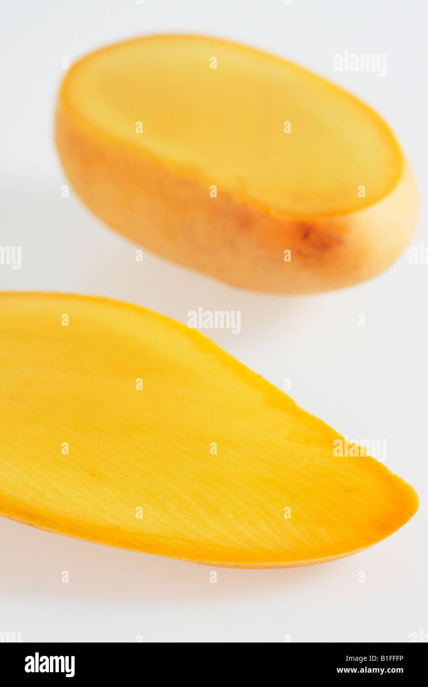 Cut Open Halves Of Mango On White Background In Studio Stock Photo
