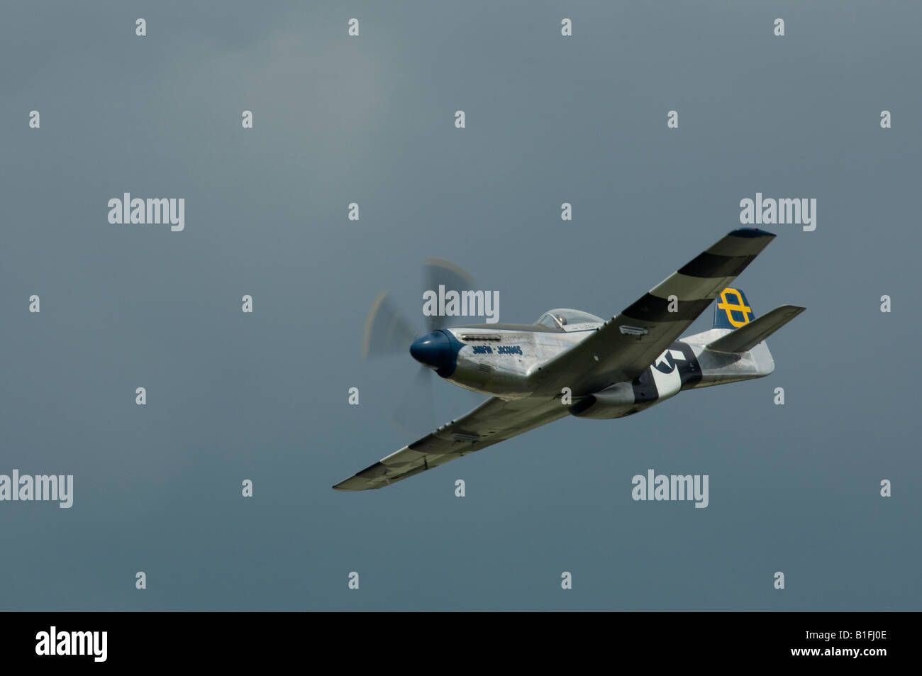 An American P51 D Mustang WW2 fighter aircraft flying under a heavy sky Stock Photo