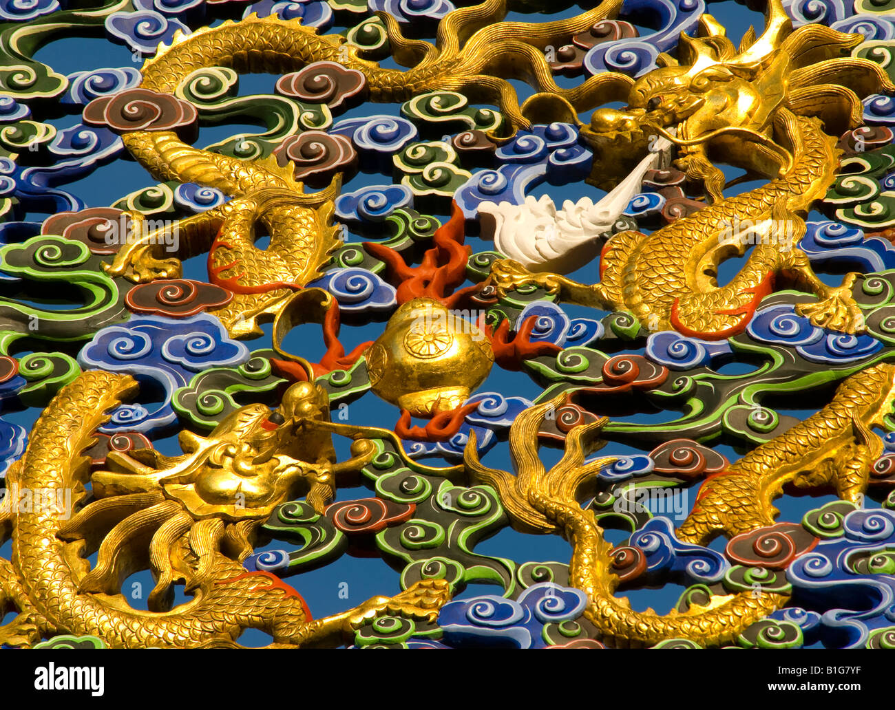 Traditional Chinese dragon design carved into wood and painted gold and blue Stock Photo