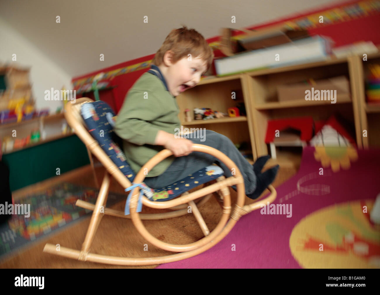 young boy rocking on a rocking chair Stock Photo