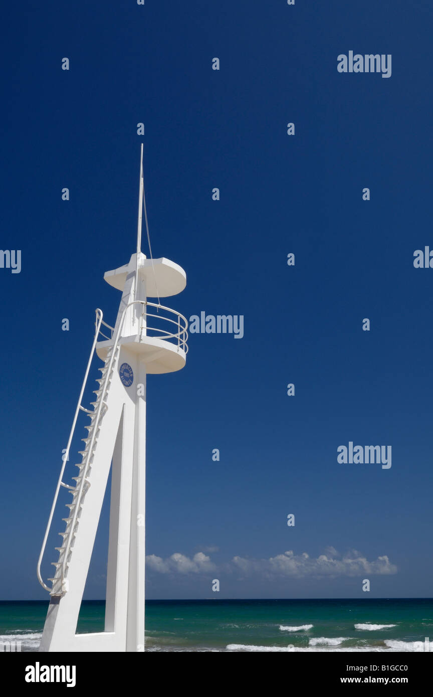A white lifeguard lookout tower on a Spanish beach against a blue sky. Stock Photo