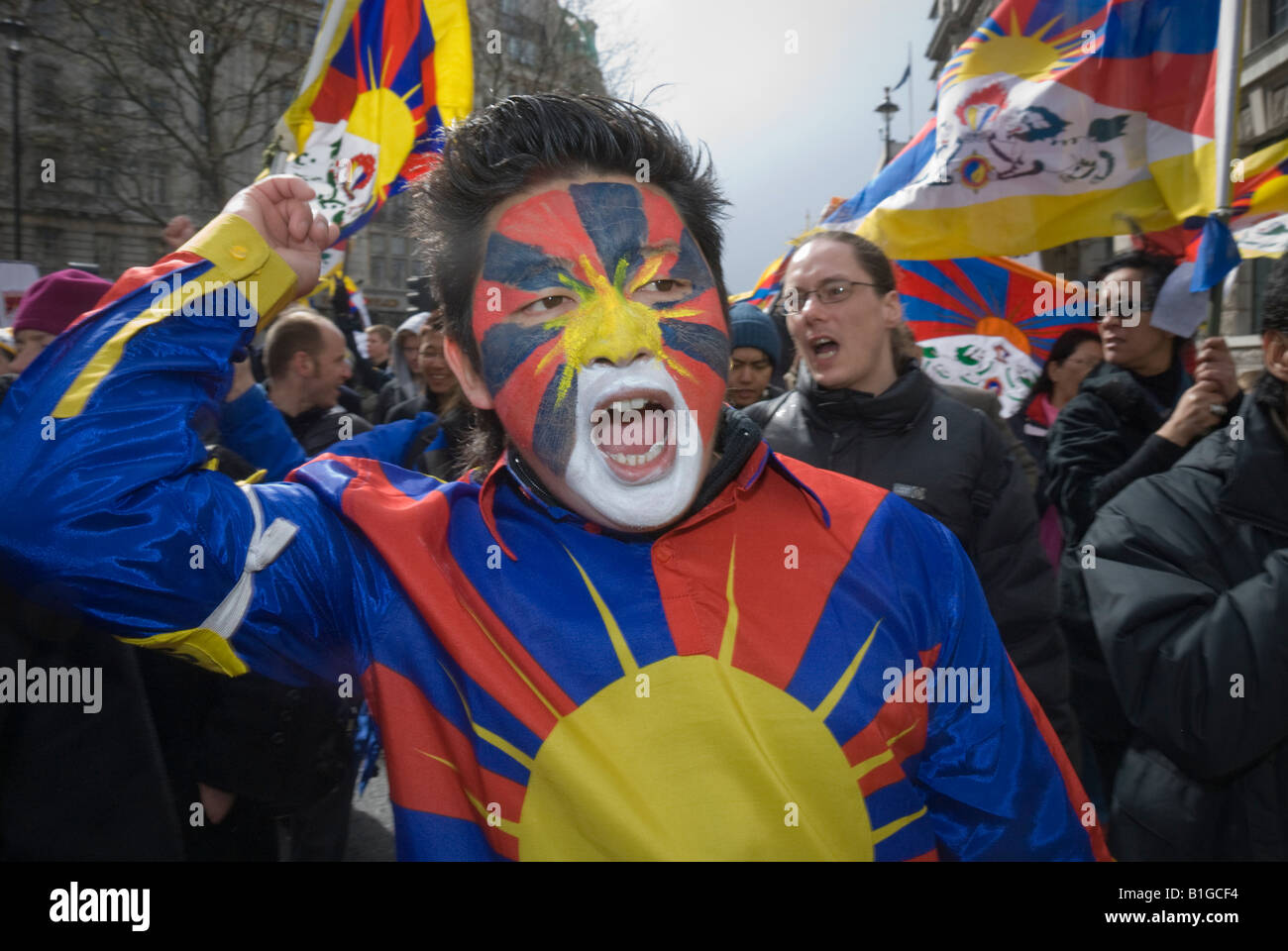 Protester with Tibetan face paint and flag in London Support Tibet march calling for an end to human rights abuses by China Stock Photo