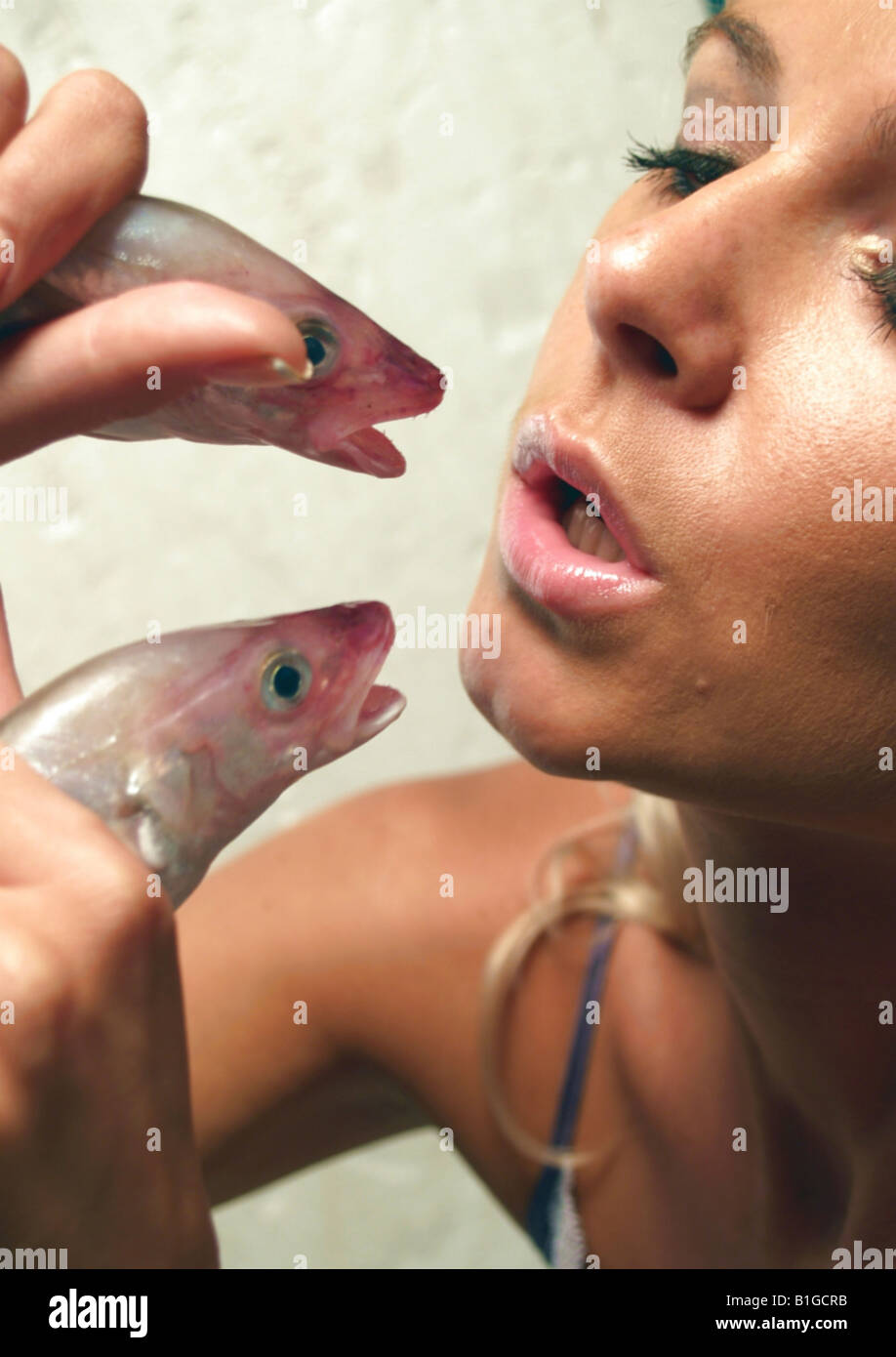 Closeup of a young woman eating raw fishes Stock Photo - Alamy