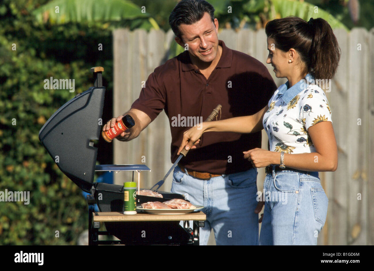 Family cooking BBQ in back yard, Stock Photo