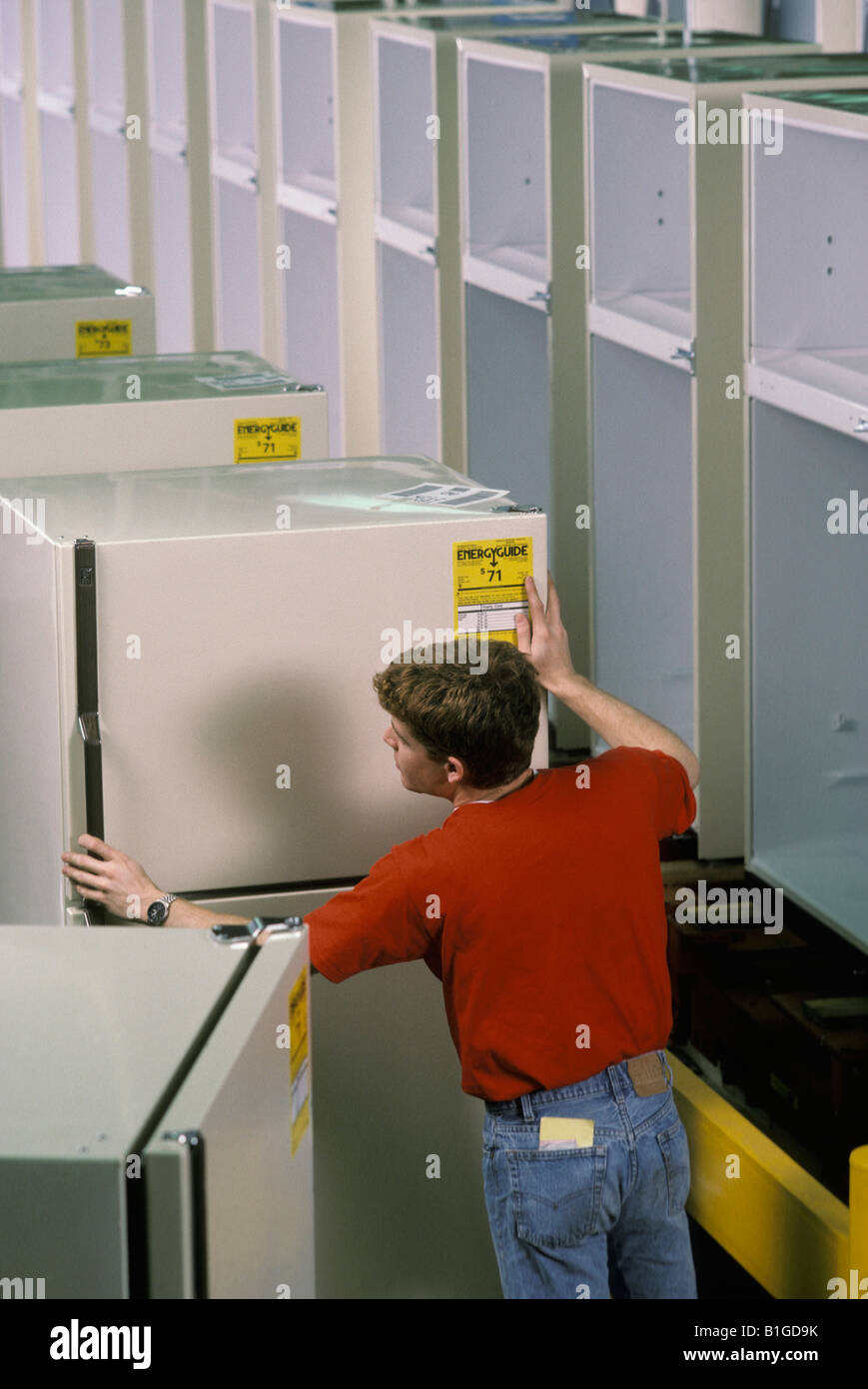Workman inspecting a refrigerator Stock Photo
