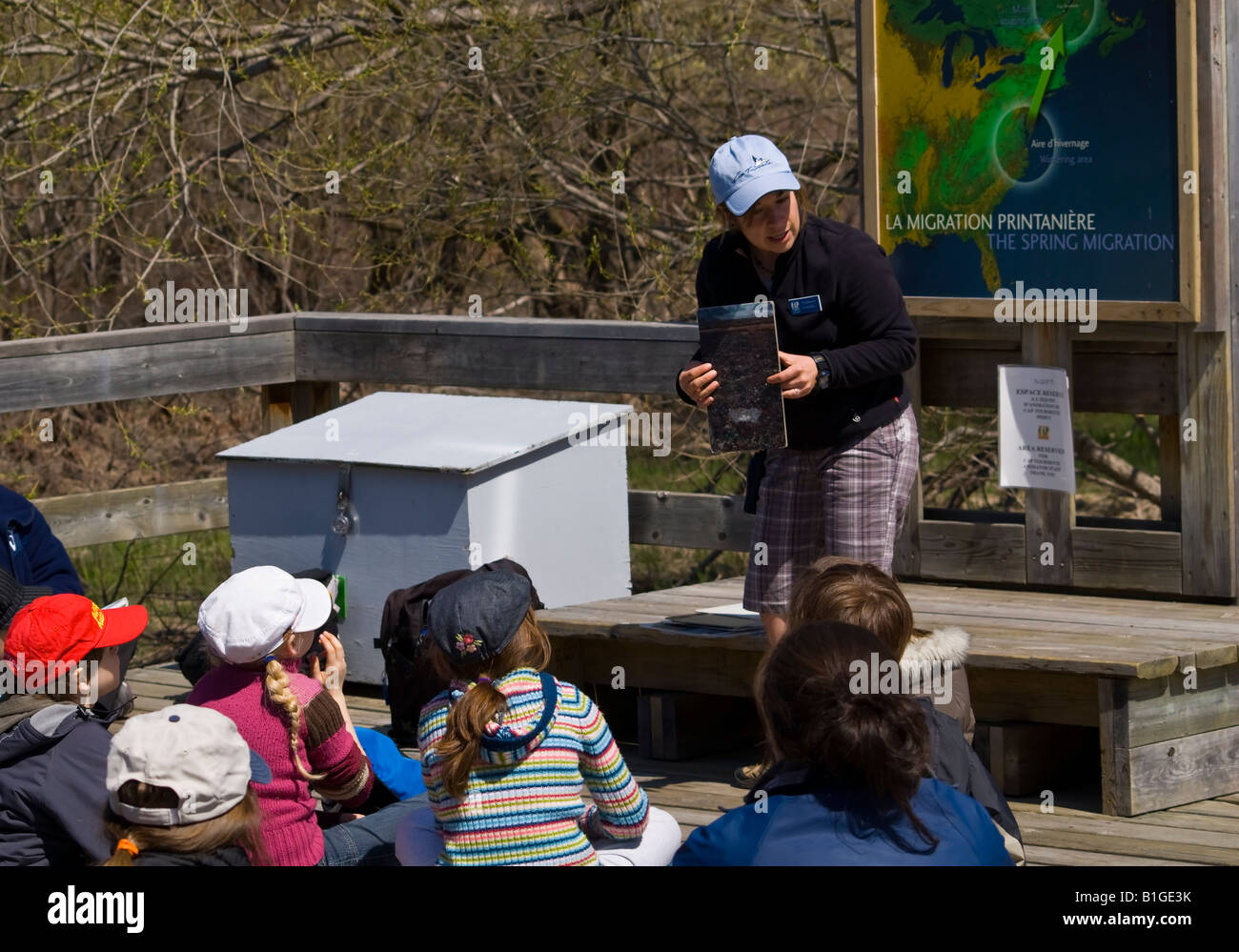 A naturalist guide with a group of children explain the flora and fauna of the area Stock Photo
