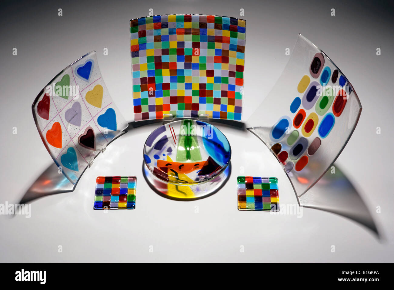 Collection of clear glass plates with colours on them in various shapes