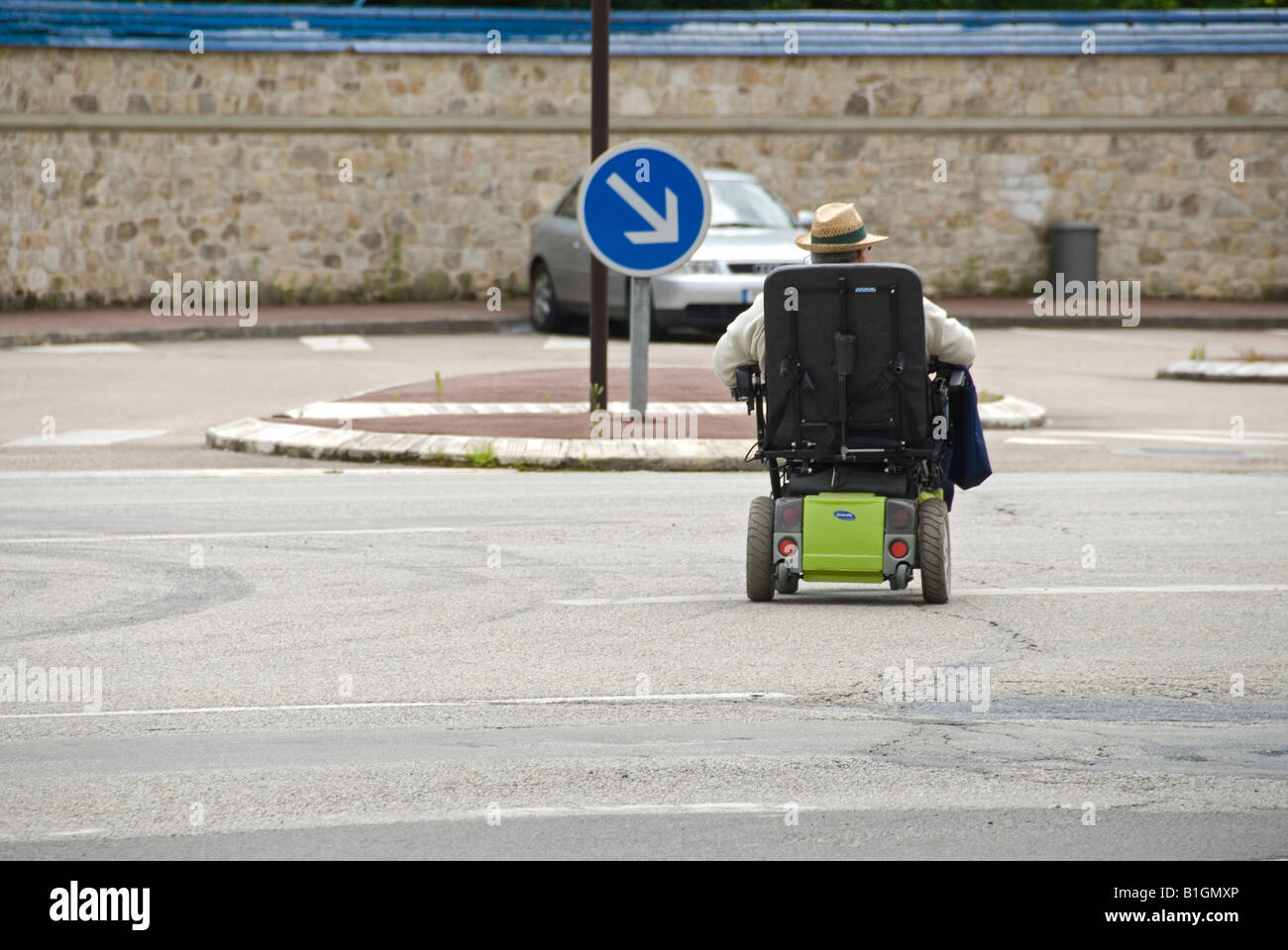 Stock photo of a man in his electric wheelchair crossing a main road ...
