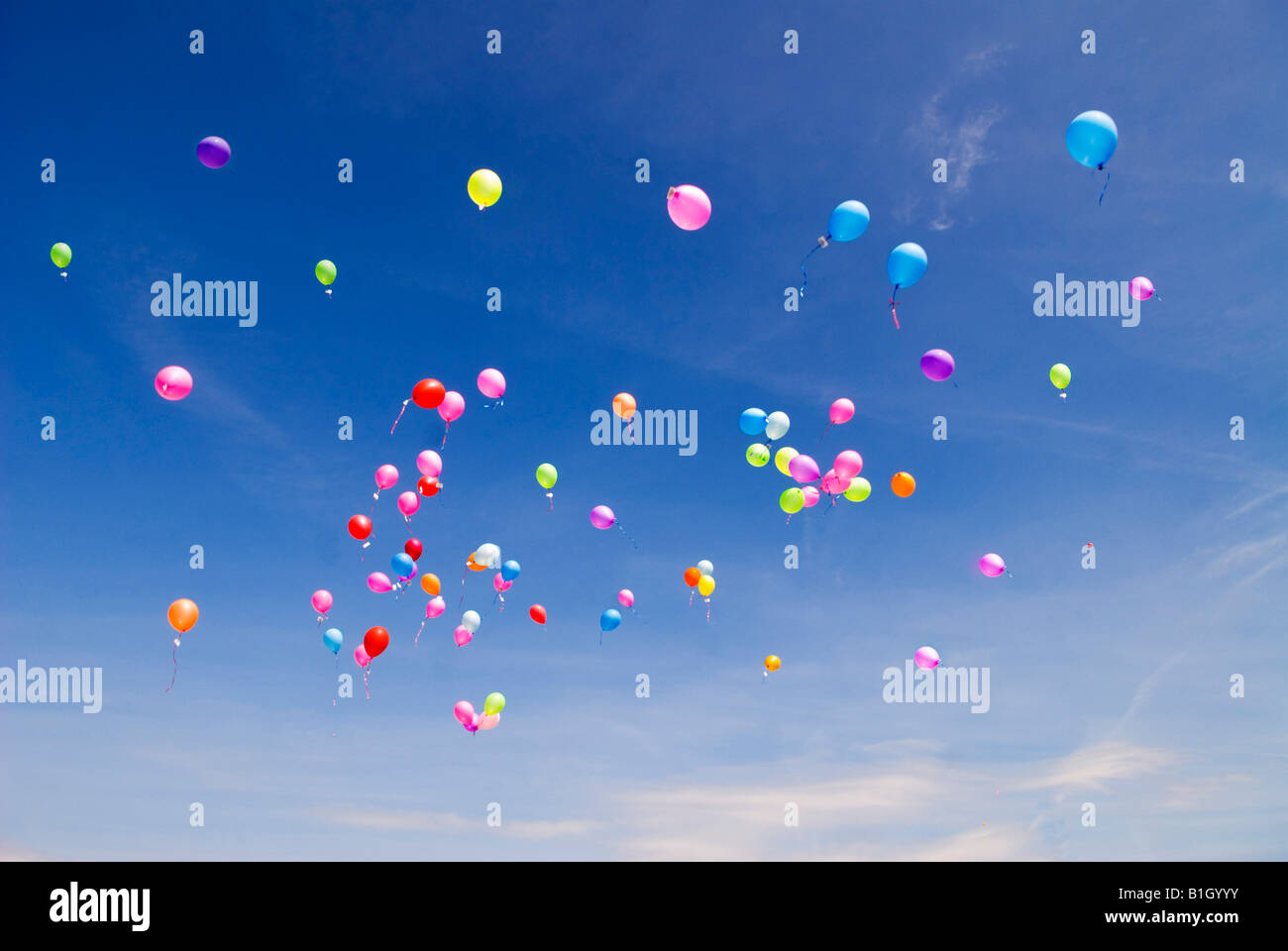 High flying balloons against blue sky Stock Photo