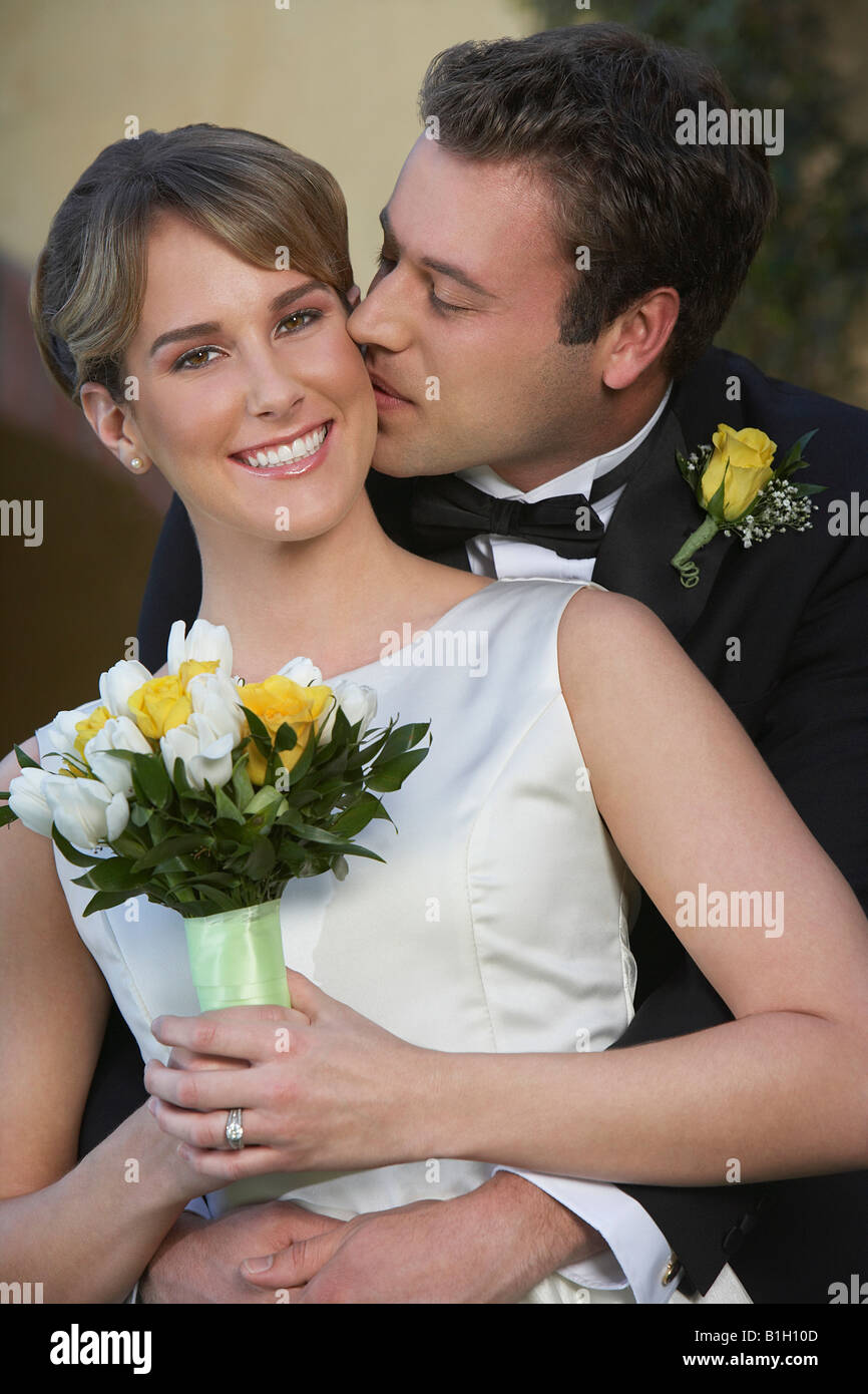 Groom kissing bride from behind Stock Photo - Alamy