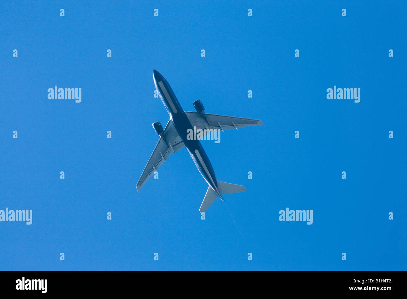 Airplane in blue sky Stock Photo - Alamy