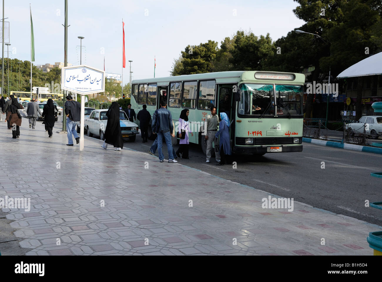A bus collecting and waiting passengers at Enghelab.E.Eslami Square, Esfahan, Iran, during early morning rush hour. Stock Photo