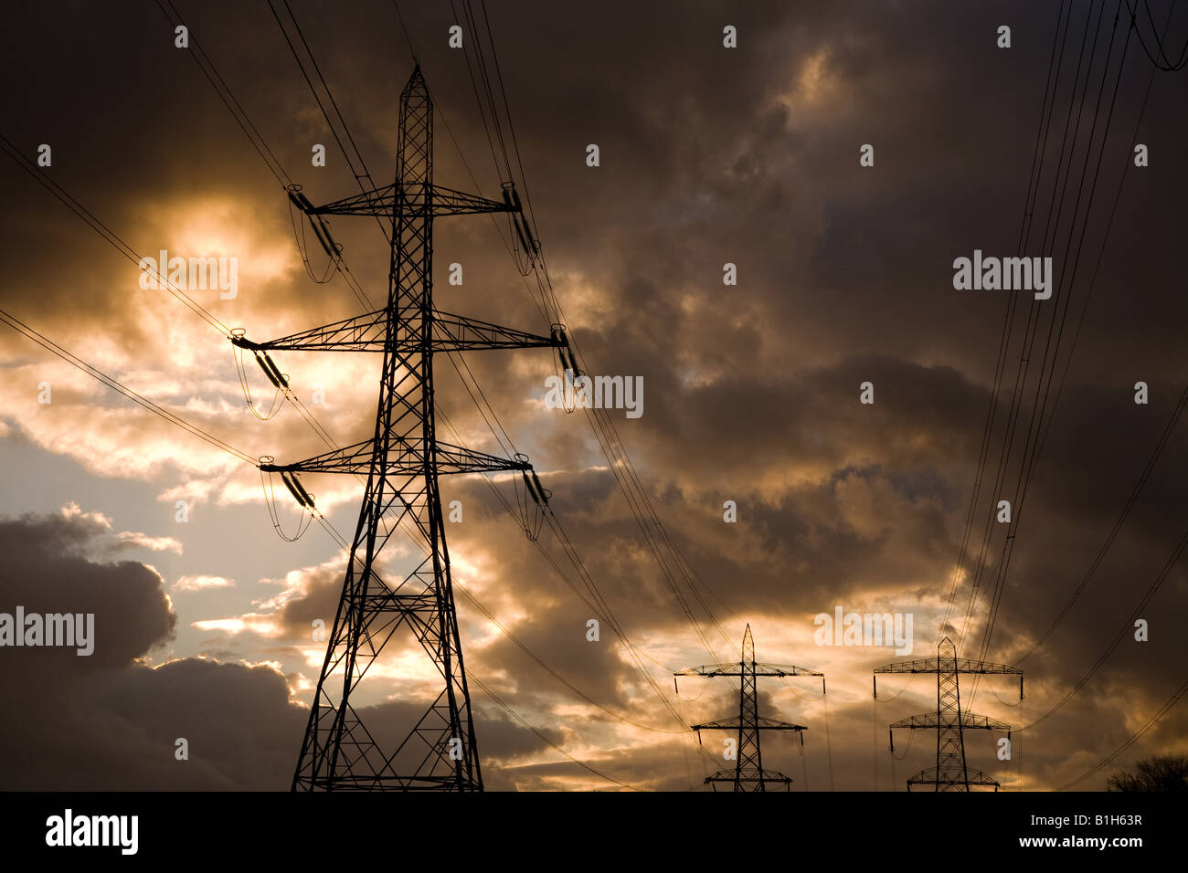 Electrical towers and a cloudy sky Stock Photo - Alamy