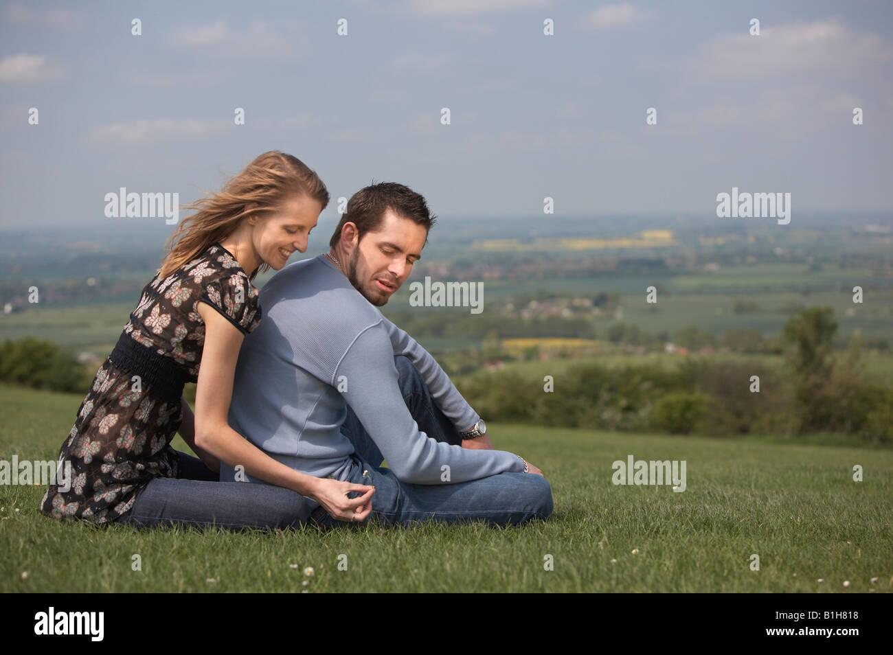 Young couple sat on grass Stock Photo - Alamy