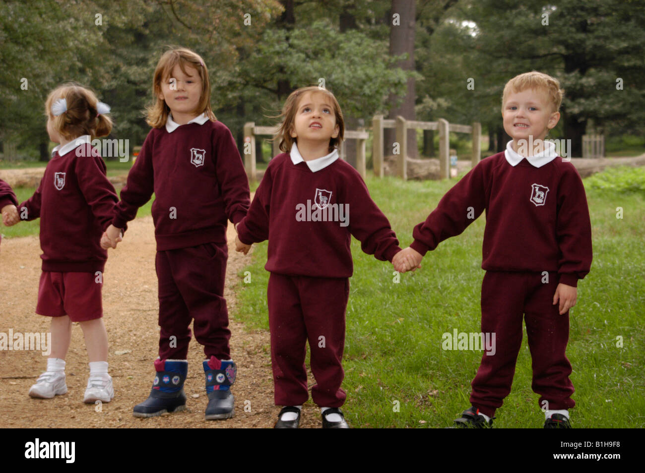 School children standing in a park holding hands Stock Photo - Alamy