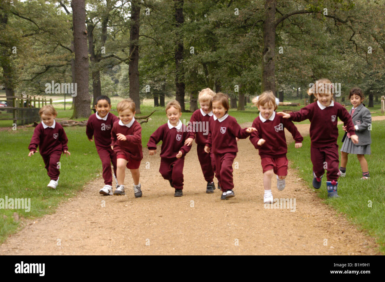 School children running through a park Stock Photo