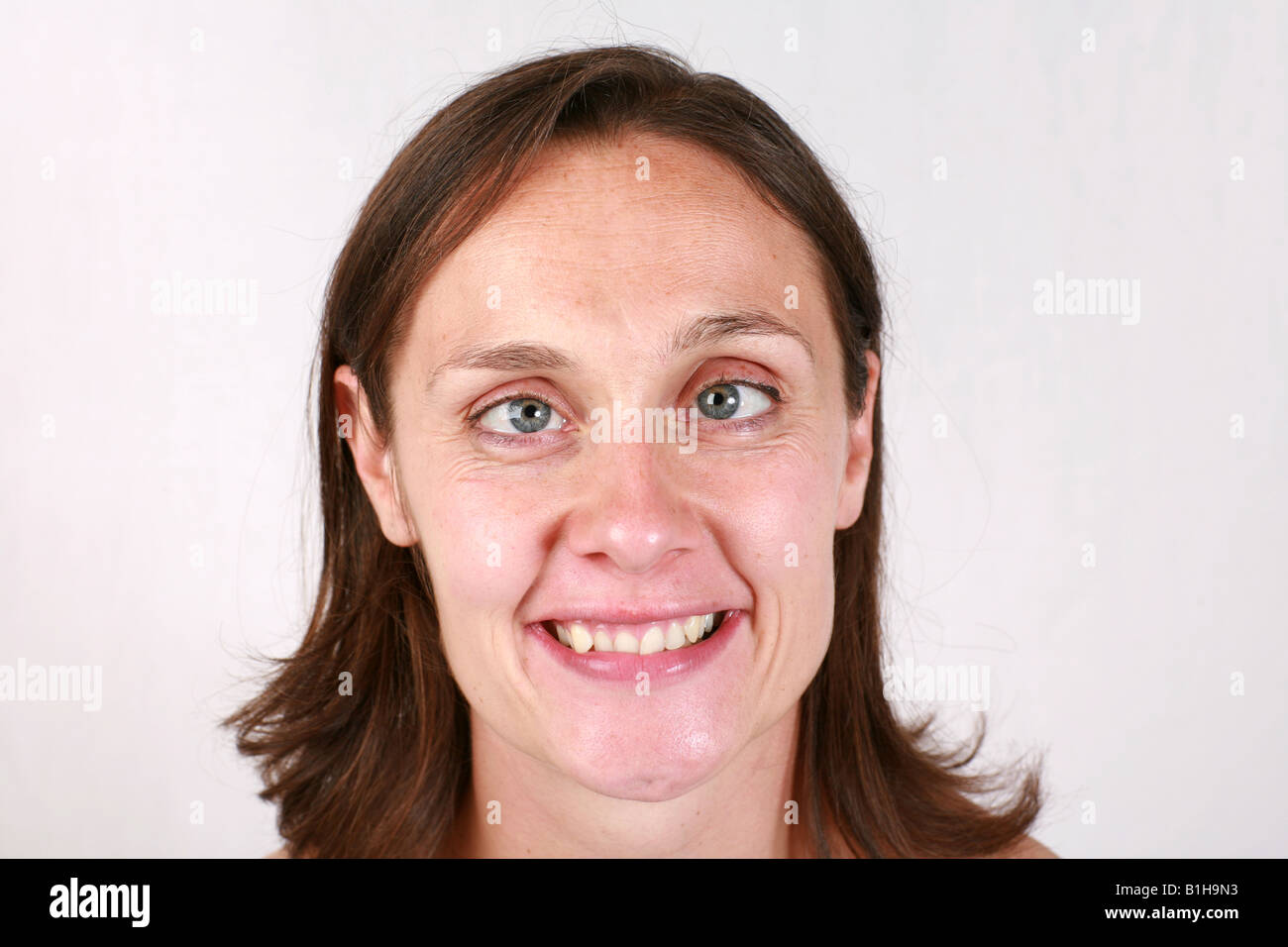 Young brunette woman closeup head shot comical funny humorous cross eye ...