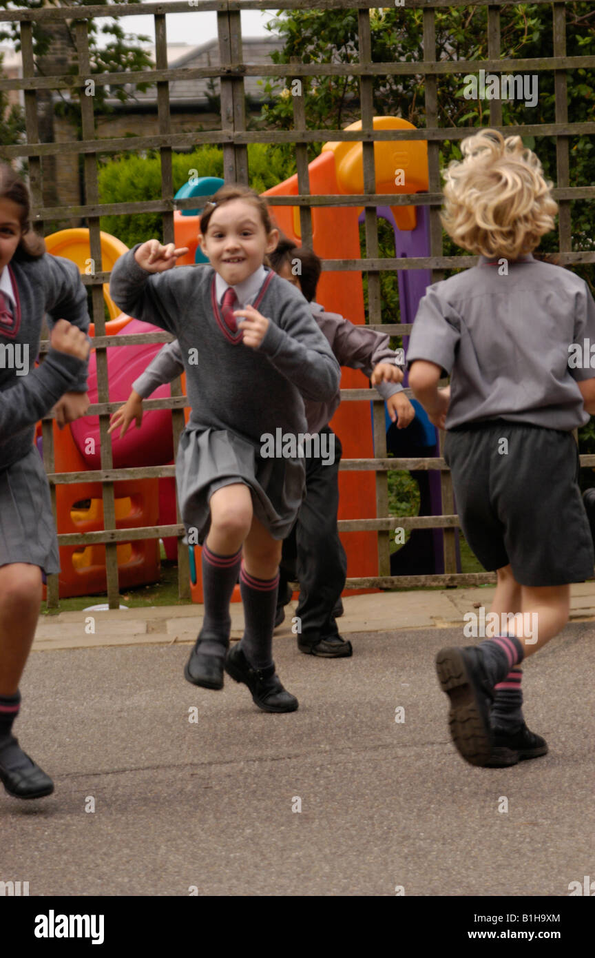 junior school children in uniform playing in the playground Stock Photo